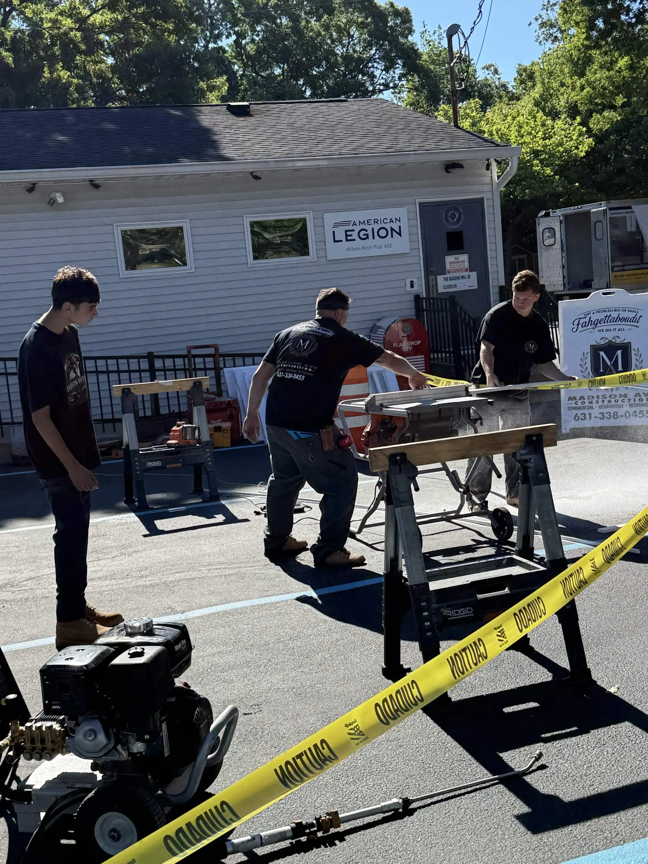 Madison Ave Construction crew building canopy framing outside the American Legion post