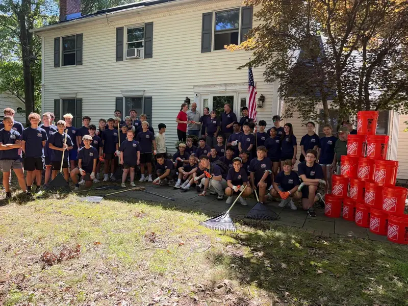 More than 50 students who restored a local veteran's yard through Youths Helping Heroes at Home